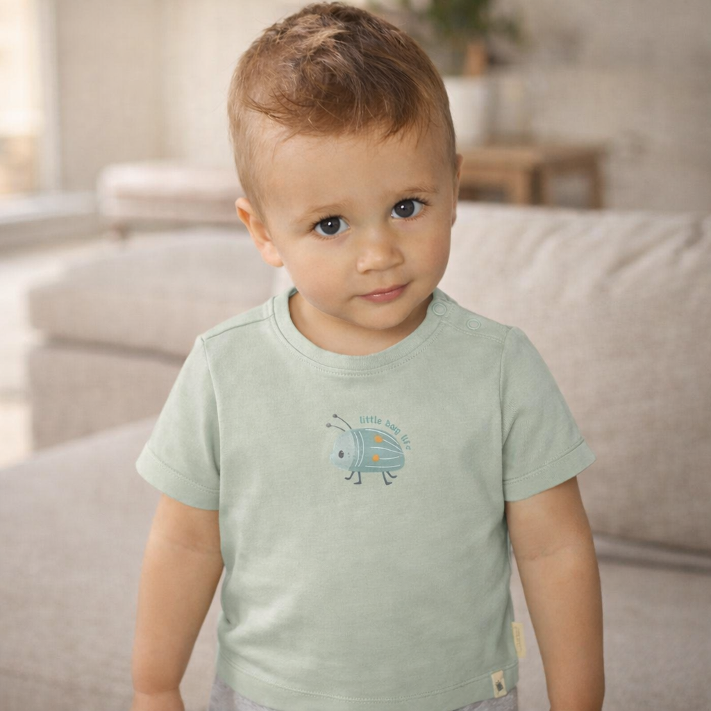 Kind trägt grünes Little Dutch Forest Mint Kurzarm-T-Shirt mit Käfermotiv