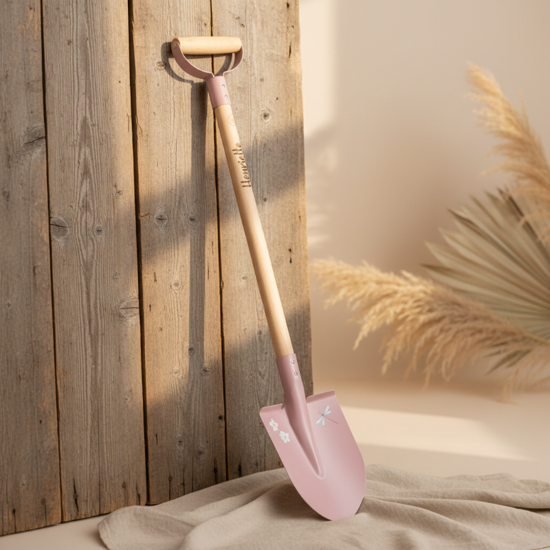 Personalisierte Kinder Gartenschaufel aus Holz mit Name Lean, dekorativ vor Holzwand und Sand, Geschenk für Kinder Garten