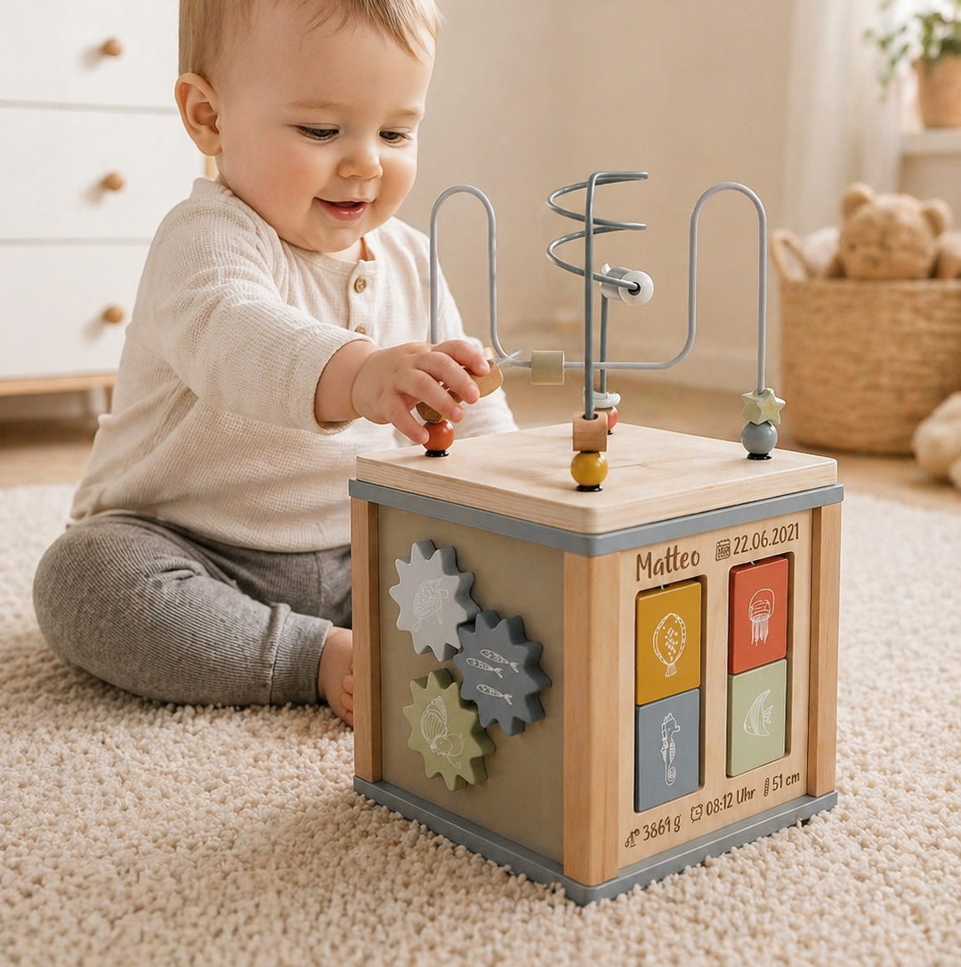 Baby mit personalisiertem Ocean-Motorikwürfel aus Holz im Kinderzimmer
